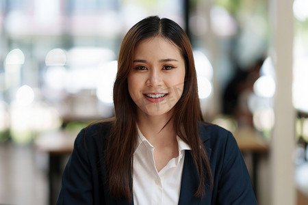 微笑在办公空间的聪明的亚裔女商人。