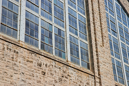建筑外墙摄影照片_不同颜色褪色窗板的工业建筑外墙