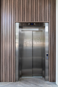 电梯扶手摄影照片_站立在商务中心底层的现代电梯门