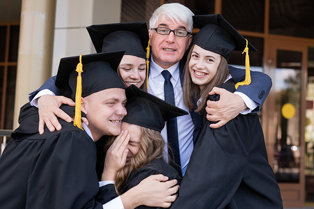 一位头发花白的男老师祝贺学生们从大学毕业。