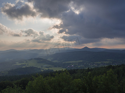 Lusatian 山脉 (luzicke hory) 全景，从捷克与德国边境的 Hochwald (Hvozd) 山欣赏阳光蓝绿色山林和粉红色多云日落天空背景