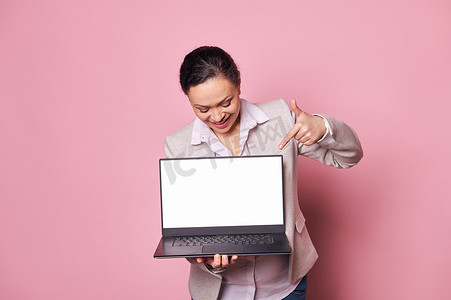 小表情摄影照片_微笑的女商人办公室职员，经理在笔记本电脑上展示一个白色数字屏幕，上面有移动应用程序的复制空间