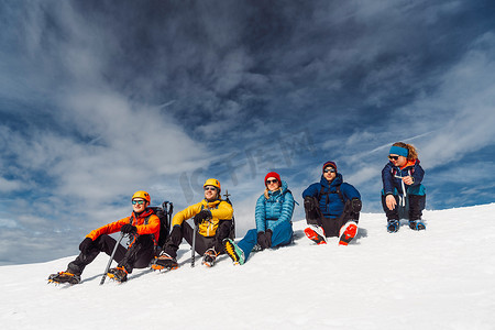 五化摄影照片_五名登山者坐在太阳上，在白雪皑皑的阿尔卑斯山高处