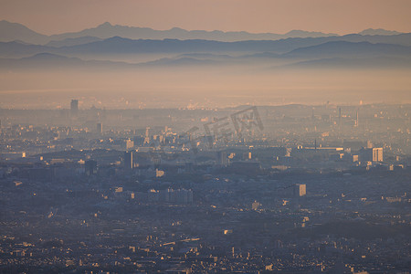 日出时，广阔的城市与雾霾层和远山融为一体