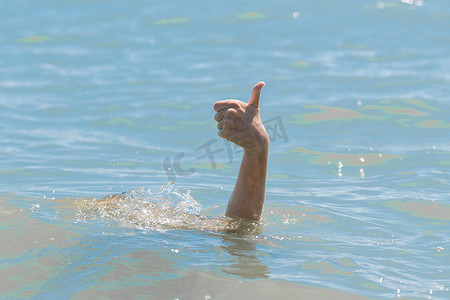 溺水女孩从水下伸出的手竖起大拇指展示课堂。