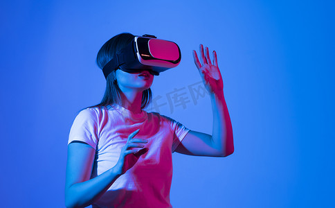 黑发女建筑师或工程师戴着 VR 耳机在虚拟现实空间中设计 3D 建筑模型。