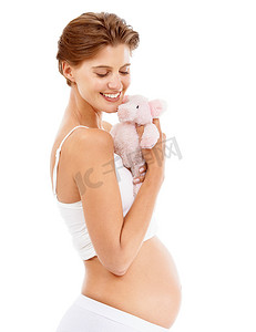 怀孕、泰迪熊宝宝和快乐的女人带着爱和大肚子对儿童玩具微笑。