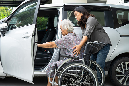 护理人员帮助和支持坐在轮椅上的亚洲老年妇女准备上车去度假。