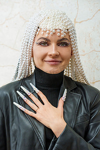 女艺术家用装饰过的假指甲展示一只手