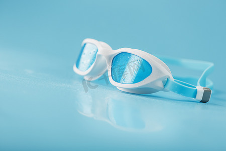 蓝色背景中白色框架中的游泳镜