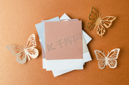 蝴蝶粉色背景摄影照片_空白笔记粘合剂纸为您的文本或消息和黄色背景上的纸蝴蝶。