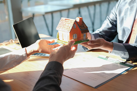 律师保险经纪人给夫妇客户提供房屋模型。