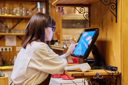 客户端电脑摄影照片_女餐厅员工在为顾客服务时使用电脑终端