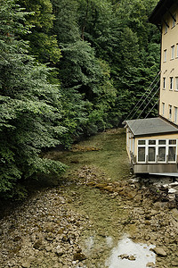 德国巴伐利亚 Mangfall 河上被巨大、茂密的绿树环绕的造纸厂