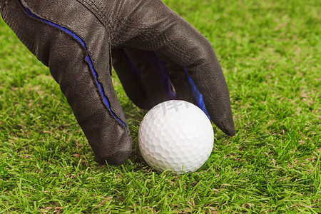 高尔夫球手在草地上捡起高尔夫球