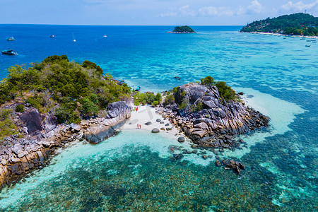在泰国丽贝岛前的一个小岛上划着皮划艇的情侣