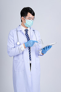 带平板电脑和 Stethos 的戴面具的医生执业医生