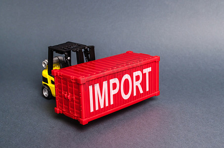 一辆叉车运载着一个标有“进口”标签的红色货运集装箱。