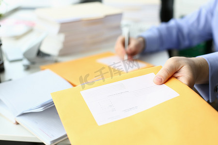 传票摄影照片_秘书在黄色邮政信封上填写地址以发送信件