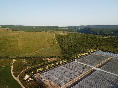 农村麦田环绕的温室工厂鸟瞰图。