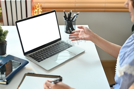 女性自由职业者在笔记本电脑上在线工作并在笔记本上做笔记的剪影