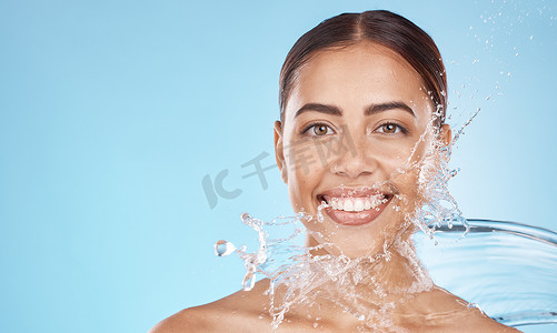 在医疗健康、卫生维护或美容模型中，快乐的女人、面部护肤品或水溅在蓝色背景工作室。