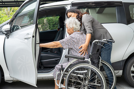 护理人员帮助和支持坐在轮椅上的亚洲老年妇女准备上车去度假。
