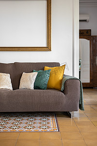 客厅的片段，配有带枕头、地砖和装饰元素的舒适室内沙发。
