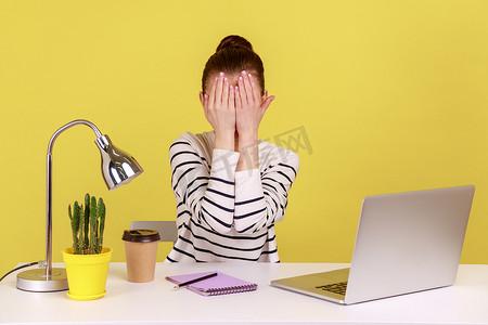兴奋的女人用手闭上眼睛，避免看一些可耻的东西，在家办公室工作。