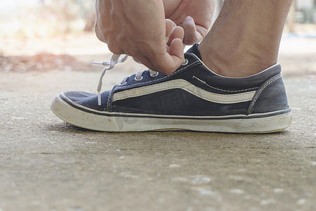 男运动员系鞋带准备跑步锻炼。