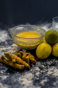 克力摄影照片_木质表面上的柠檬面罩，由柠檬汁、克面粉或鹰嘴豆粉、姜黄或 Haldi 和玻璃碗中的牛奶组成。用于治疗晒黑。