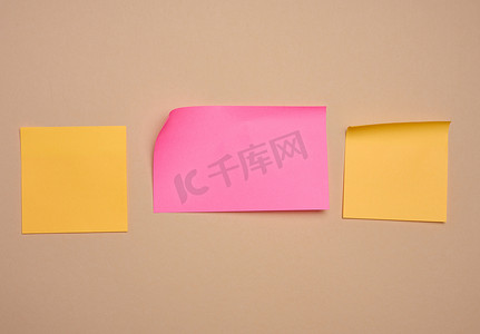 粉色笔记摄影照片_米色背景上用于笔记的多色纸贴纸，用于写入数据、笔记的地方