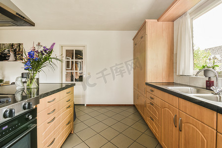 窗户台摄影照片_带木柜和黑色台面的厨房