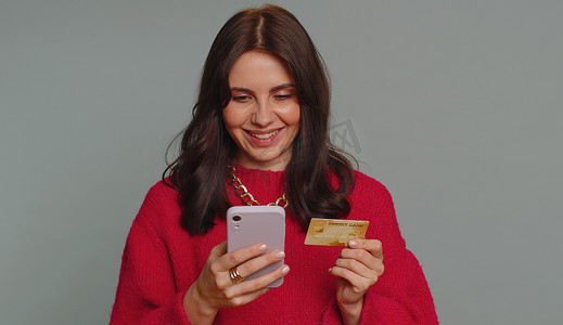 年轻女性在转账购买网上购物时使用信用卡和智能手机
