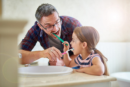 请记住，每天两次，两分钟……一位父亲和他的女儿刷牙。