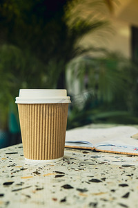 热拿铁咖啡在工艺回收纸杯与纸笔记本。