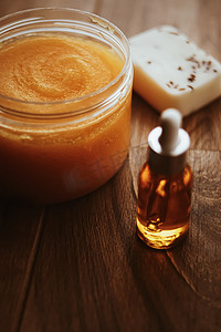 质朴木质背景的柑橘和蜜橙身体磨砂罐、美容化妆品和护肤品