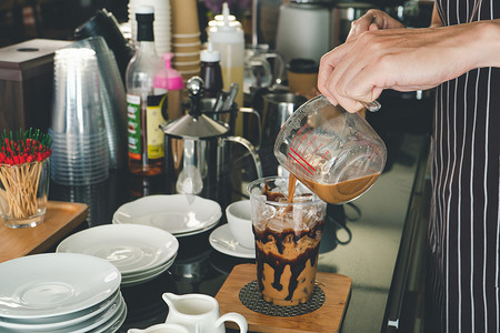 自助饮品摄影照片_咖啡师正在咖啡店制作饮品。