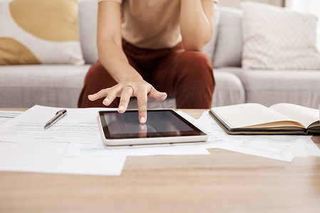 女人，在家里用纸和平板电脑做预算，以审查财务或在线投资合同。