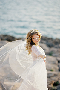 石子摄影照片_迎风飘扬的新娘站在石头上，张开双臂
