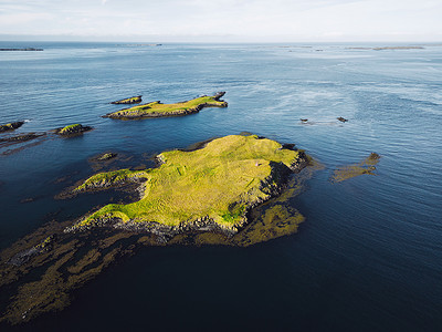 海中小岛摄影照片_Stykkisholmur 的岩石海岸，海中有许多小岛