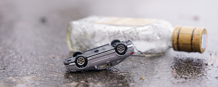 交通事故-一辆翻倒的汽车，背景是一瓶酒精。
