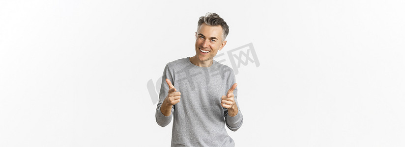 厚颜无耻摄影照片_厚颜无耻的中年男子，留着灰色短发，用手指指着镜头微笑，称赞出色的工作或祝贺，站在白色背景上