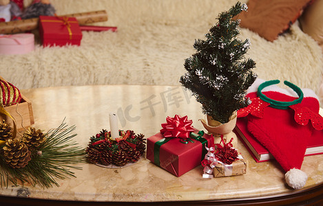 一张大理石桌子的顶视图，上面放着礼物、圣诞树、点燃的蜡烛。