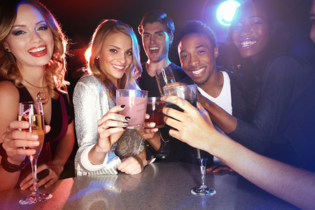 朋友喝鸡尾酒，在夜总会敬酒，在派对肖像中微笑，与快乐的人一起庆祝新年。