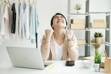 企业主年轻的亚洲女性在收到客户的新订单后很高兴。