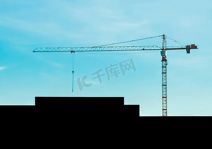蓝天背景下的城市塔吊与施工现场建筑物的几何轮廓