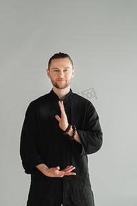 一个穿着黑色和服的男人在室内练习气功能量练习
