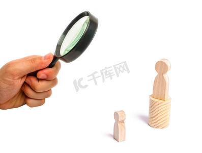 传达摄影照片_Magnifying glass is looking 放大镜正在看着站在讲台上的人，向听众传达他的想法和想法。
