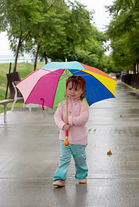 人在雨中摄影照片_站在雨中打伞的小女孩